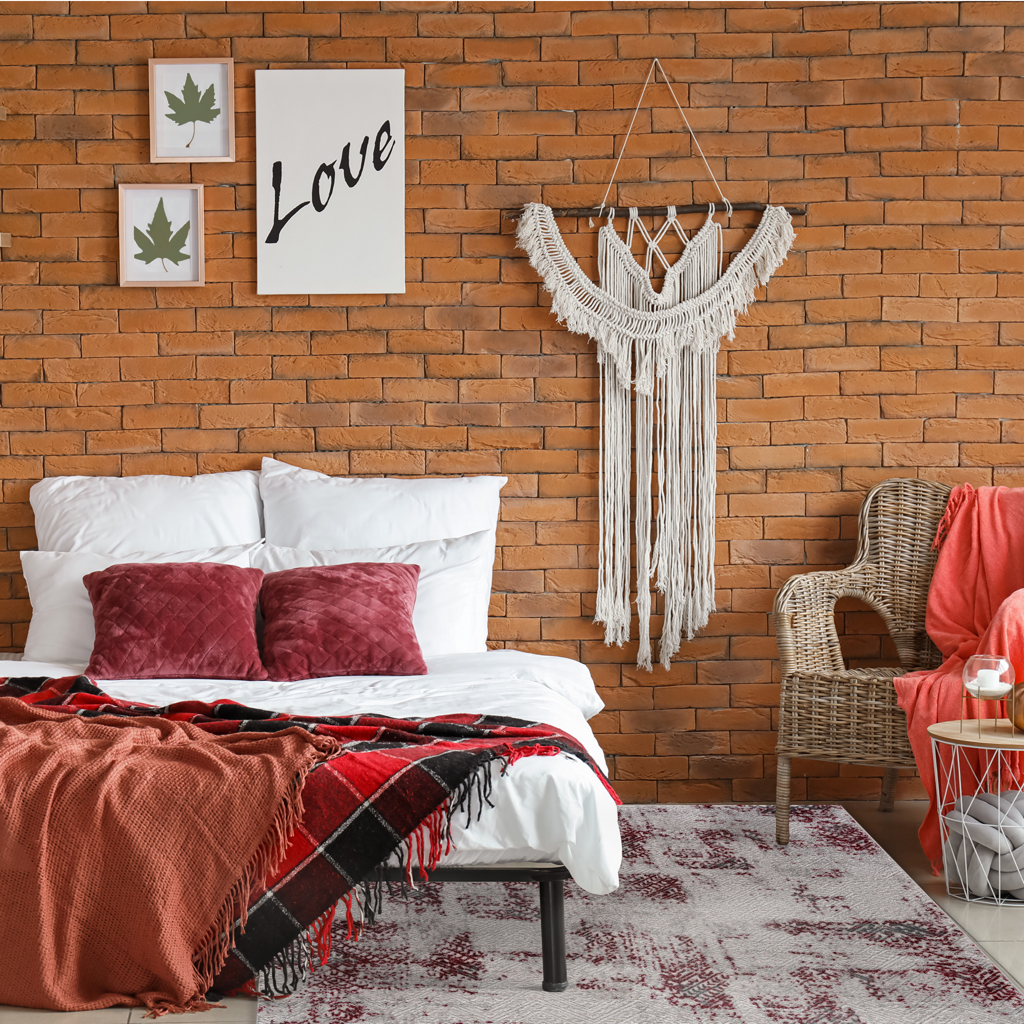 Bohemian bedroom with exposed brick, rattan chair, macrame wall hanging, Istanbul Area Rug in Christmas vibes