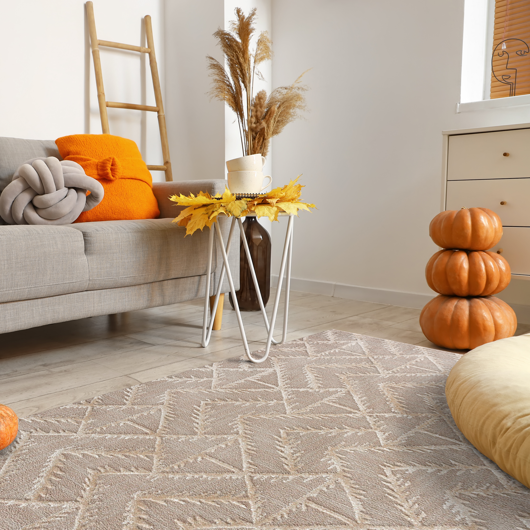 Cozy autumn family room with vibrant fall decor including beige sofa, pumpkins stack, dried leaves, coffee table and Geometric Tufted Rug